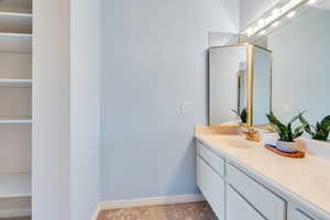 Bathroom featuring vanity, a closet, and light tile patterned floors