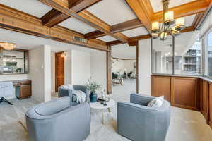 Den  featuring a chandelier, carpet, coffered ceiling, built in desk, and beamed ceiling