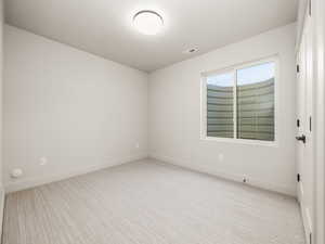 Unfurnished room with baseboards and light carpet