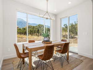 Dining area featuring healthy amount of natural light, wood finished floors, a mountain view, a chandelier, and recessed lighting