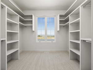 Walk in closet featuring light colored carpet