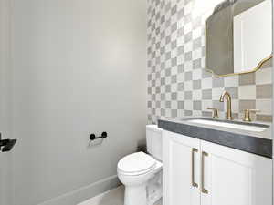 Half bath featuring vanity, backsplash, and tile walls