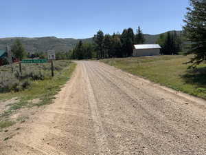 View of dirt / gravel road with a mountain view and a view of countryside