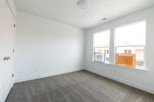 Spare room featuring carpet and baseboards
