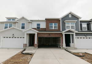 View of front of house featuring concrete driveway, an attached garage, and brick siding