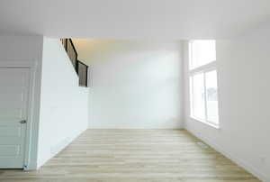Unfurnished room with light wood-style flooring and baseboards