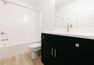 Full bath featuring shower / tub combination, vanity, and light wood-style floors