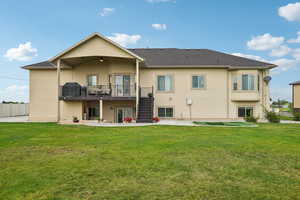 Rear view of property with stairway, a patio area, stucco siding, and a lawn