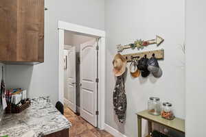 Mudroom with baseboards and dark stone finish floors