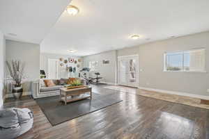 Living room featuring french doors, plenty of natural light, a textured ceiling, and wood finished floors