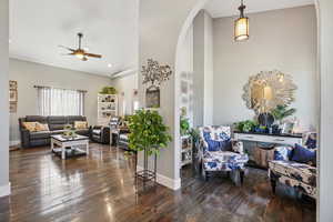 Living room featuring arched walkways, dark wood-style flooring, ceiling fan, lofted ceiling, and recessed lighting