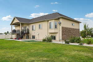 Back of house with stairs, stucco siding, a patio, and stone siding