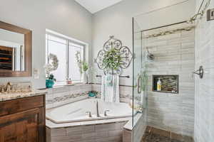 Bathroom with a bath, vanity, and a shower stall