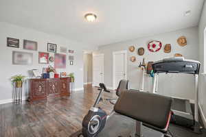 Workout room featuring wood finished floors and baseboards