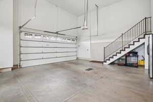 Garage with freestanding refrigerator and a garage door opener
