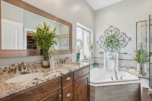 Bathroom featuring a garden tub and double vanity