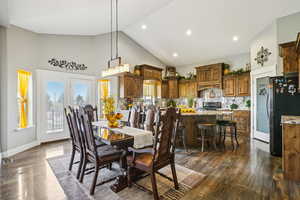 Dining room with high vaulted ceiling, dark wood finished floors, and recessed lighting