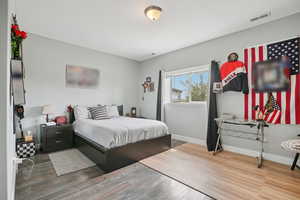 Bedroom with wood finished floors and baseboards