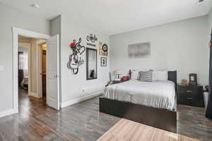 Bedroom with wood finished floors and baseboards