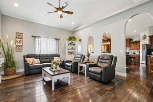 Living area featuring recessed lighting, dark wood-style flooring, arched walkways, a ceiling fan, and high vaulted ceiling