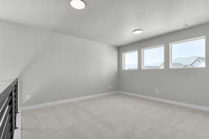 Empty room featuring light carpet and baseboards