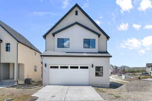 View of front of house with an attached garage, driveway, and roof with shingles