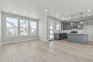 Kitchen with decorative backsplash, gray cabinetry, recessed lighting, decorative light fixtures, and light countertops