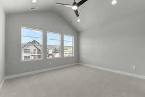 Empty room featuring light colored carpet, vaulted ceiling, ceiling fan, and recessed lighting