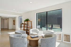 Living area featuring dark aggregate flooring and recessed lighting