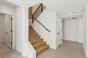 Stairs with recessed lighting and baseboards