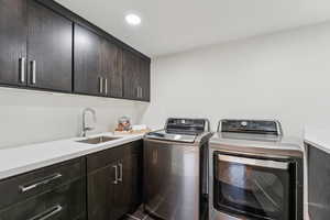 Laundry area with cabinet space, separate washer and dryer, and recessed lighting