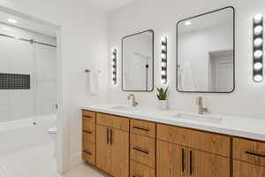 Bathroom featuring recessed lighting, combined bath / shower with glass door, double vanity, and light tile patterned floors