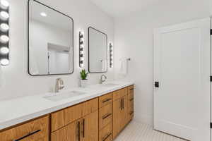 Full bathroom with double vanity and light tile patterned flooring