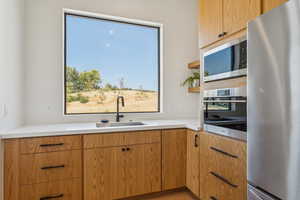 Kitchen featuring stainless steel appliances, open shelves, and modern cabinets