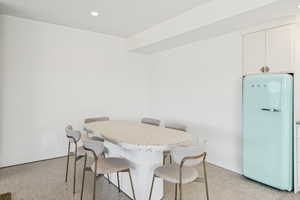 Dining room with recessed lighting and dark aggregate flooring