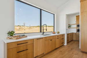Kitchen featuring light wood-type flooring, modern cabinets, open shelves, and appliances with stainless steel finishes