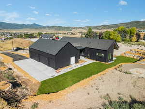 Aerial view of property and surrounding area featuring a mountainous background