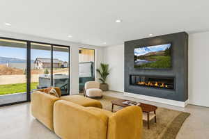 Living room featuring recessed lighting, a large fireplace, and dark speckled floor