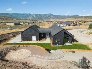 Rear view of house with a mountain view, a patio area, and a metal roof