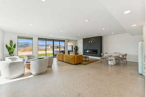 Living area featuring dark speckled floor, a fireplace, and recessed lighting