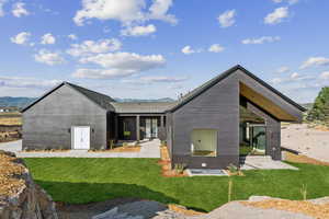 Back of house featuring a mountain view and a lawn