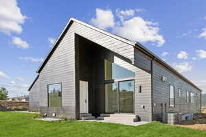 Rear view of property featuring entry steps and a yard