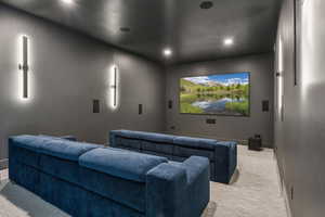 Carpeted cinema room with recessed lighting and baseboards