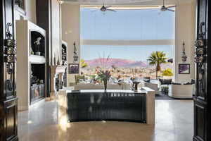 Living area with a mountain view, a high ceiling, ceiling fan, and a fireplace