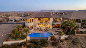 Rear view of property with a chimney, a jacuzzi, stucco siding, a fenced backyard, and a patio area