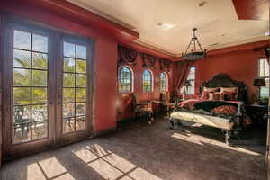 Carpeted bedroom featuring french doors and a raised ceiling