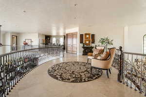 Hall featuring an upstairs landing and light tile patterned flooring
