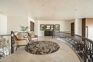 Living area featuring an upstairs landing and a textured ceiling
