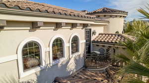 Exterior view of stucco siding and a tiled roof