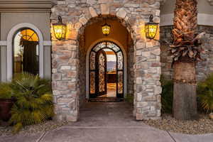 Entrance to property featuring stone siding and stucco siding